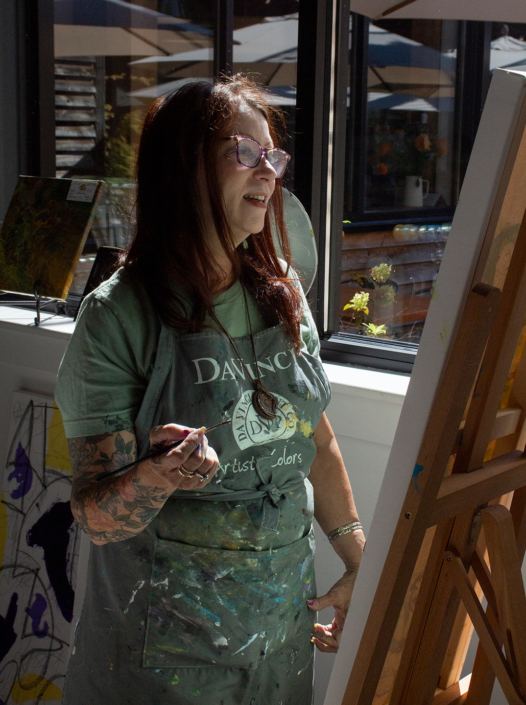 Ann Benton Yeager, a central Pennsylvania modern artist, gazing at the partially blank canvas in front of her, considering the state of her current painting and where to guide the next stroke off of her paintbrush; at The Millworks in Harrisburg PA, Sunday September 14th, 2025. Ann was one of the many artists performing a live art demonstration during the 37th Annual Harrisburg Gallery Walk; a large community event hosting dozens of local artists at different locations in Midtown Harrisburg.